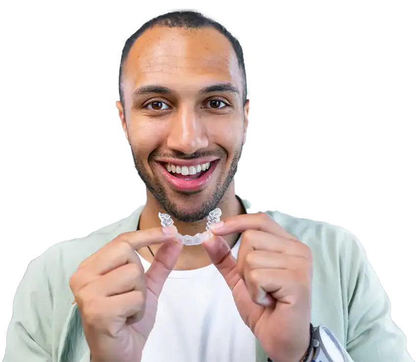 An adult holding an Invisalign aligner at Smile Spa Camarillo Dentistry
